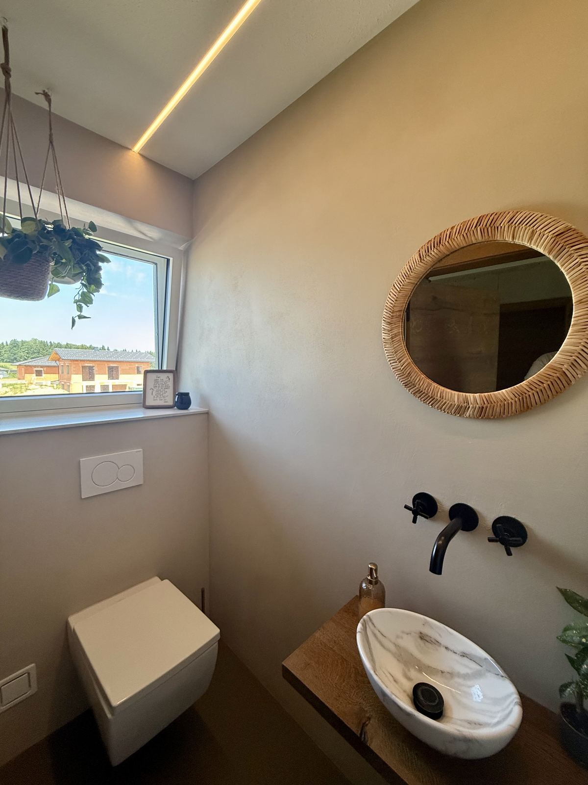 Fugenloses Bad mit Rundspiegel am Fenster