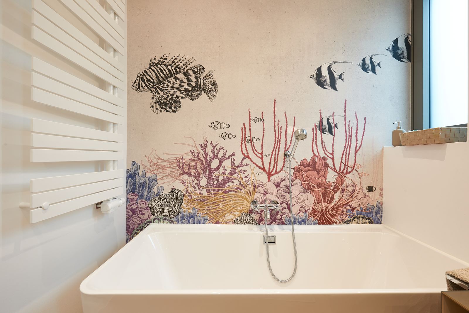 Bad mit Korallenriff-Wandbild über der Wanne