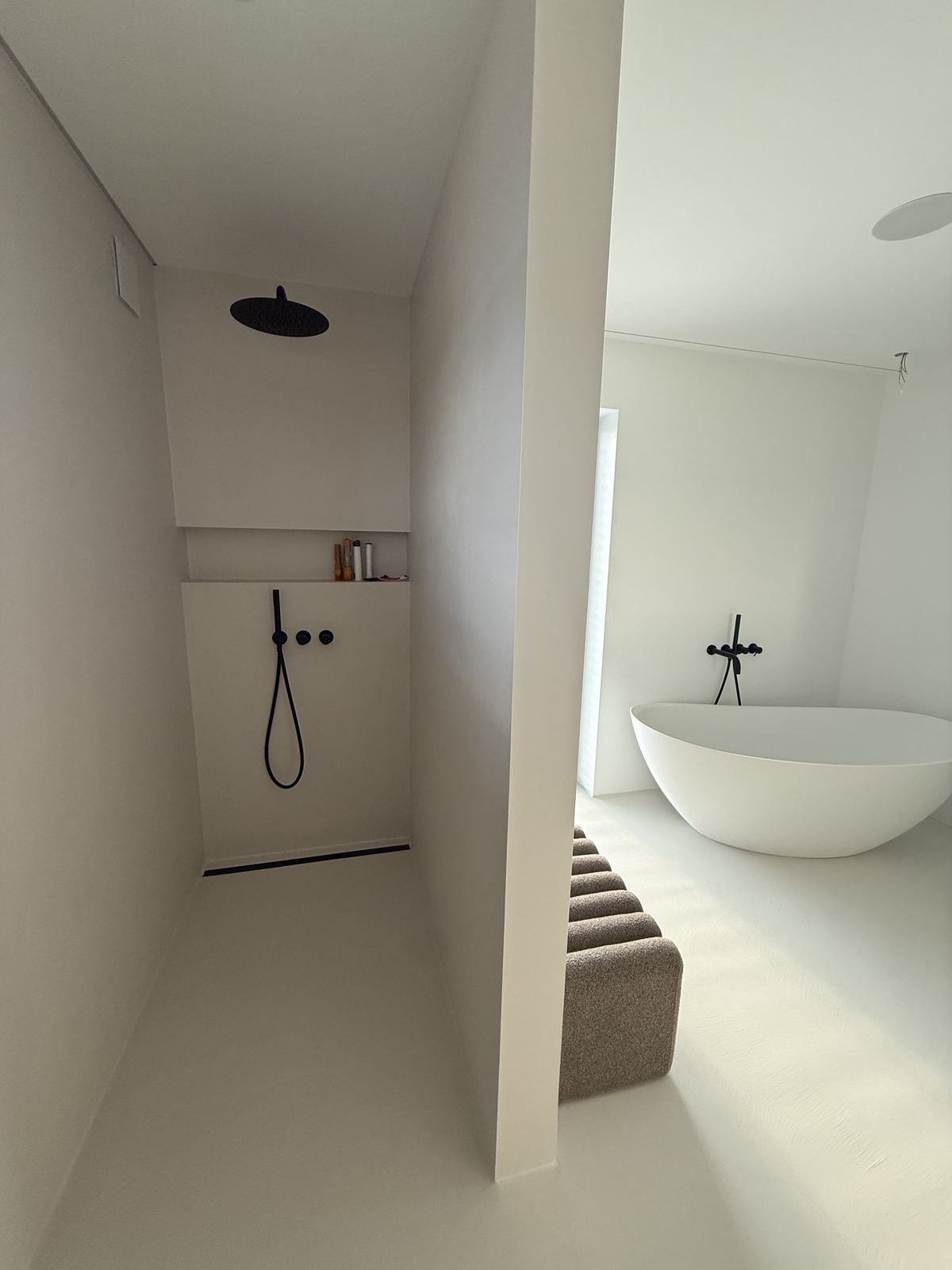 Minimalistisches weißes fugenloses Bad mit freistehender Wanne