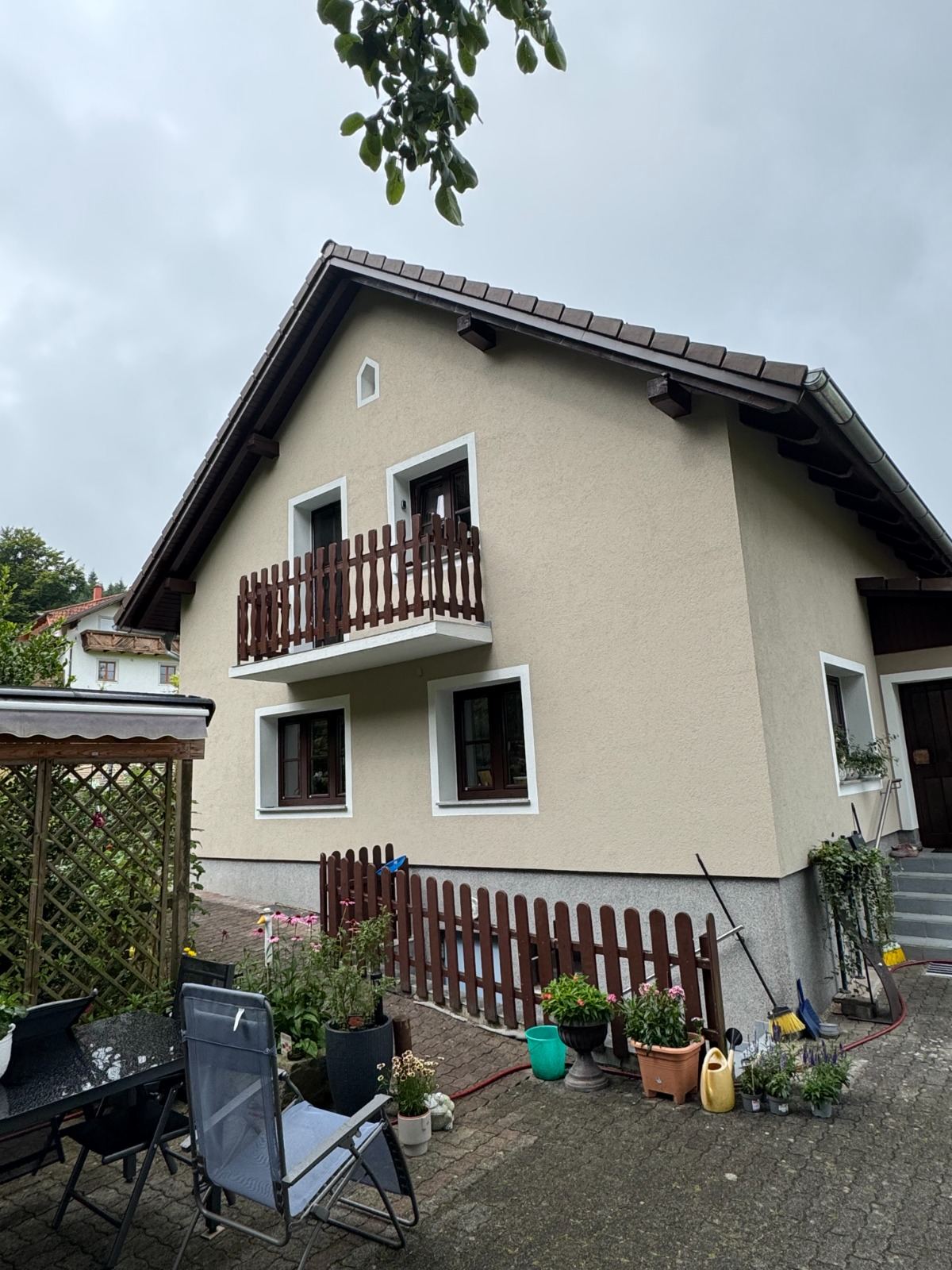 Einfamilienhaus mit Balkon und frisch gestrichener hellgrüner Fassade