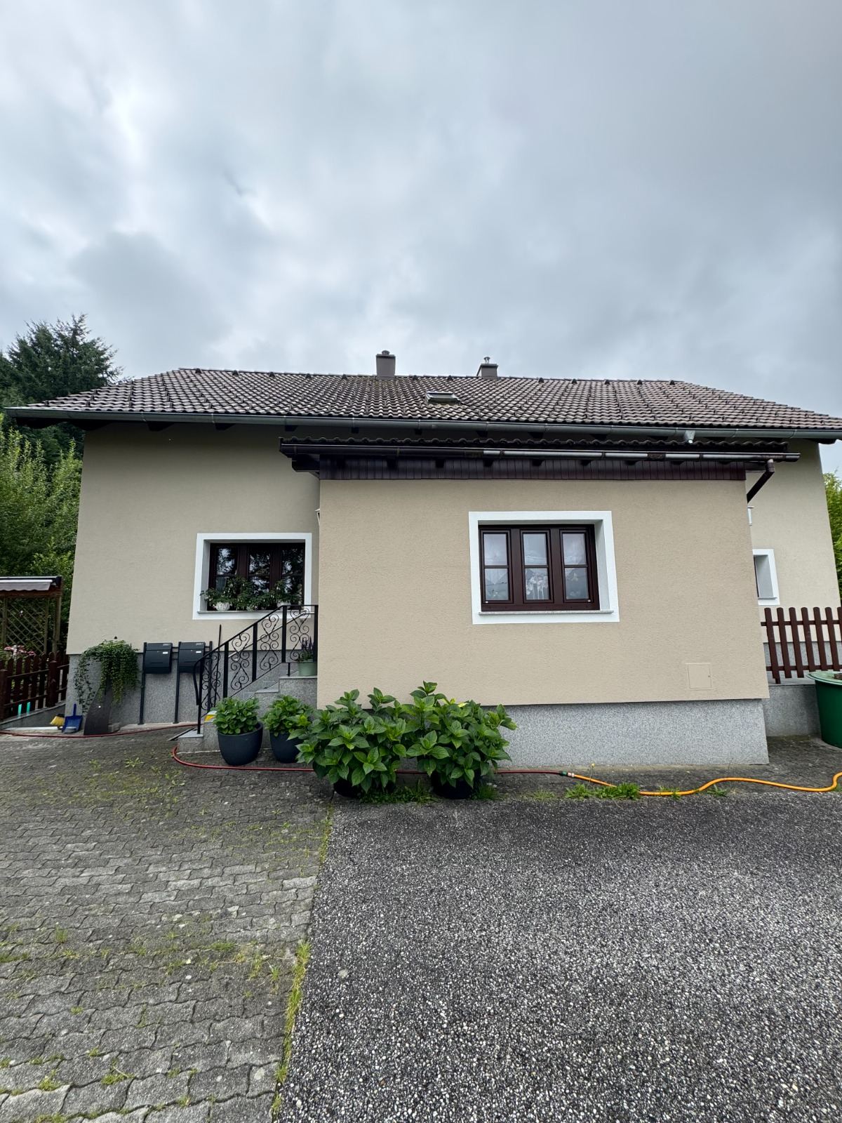 Einfamilienhaus mit hellgrüner Fassade vom Hof aus