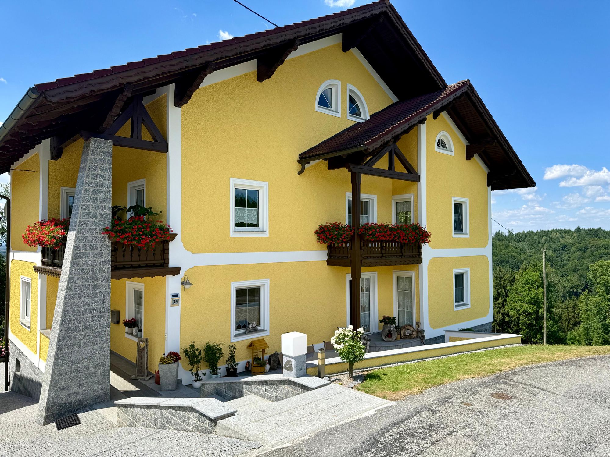 Gelbe Fassade eines gepflegten Wohnhauses mit weißen Faschen