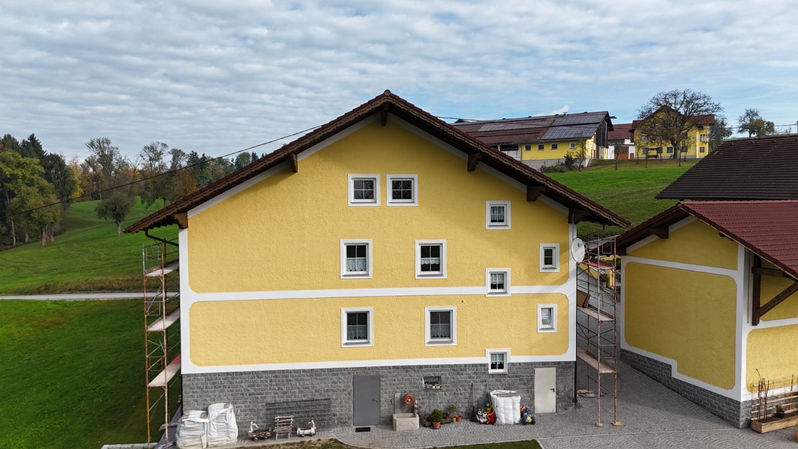 Gelbe Fassade einer Hofstelle mit Gerüst