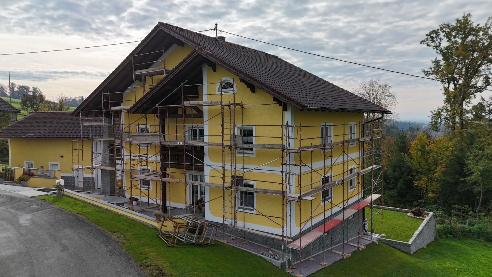 Gelbes Wohnhaus mit Gerüst kurz vor Fertigstellung