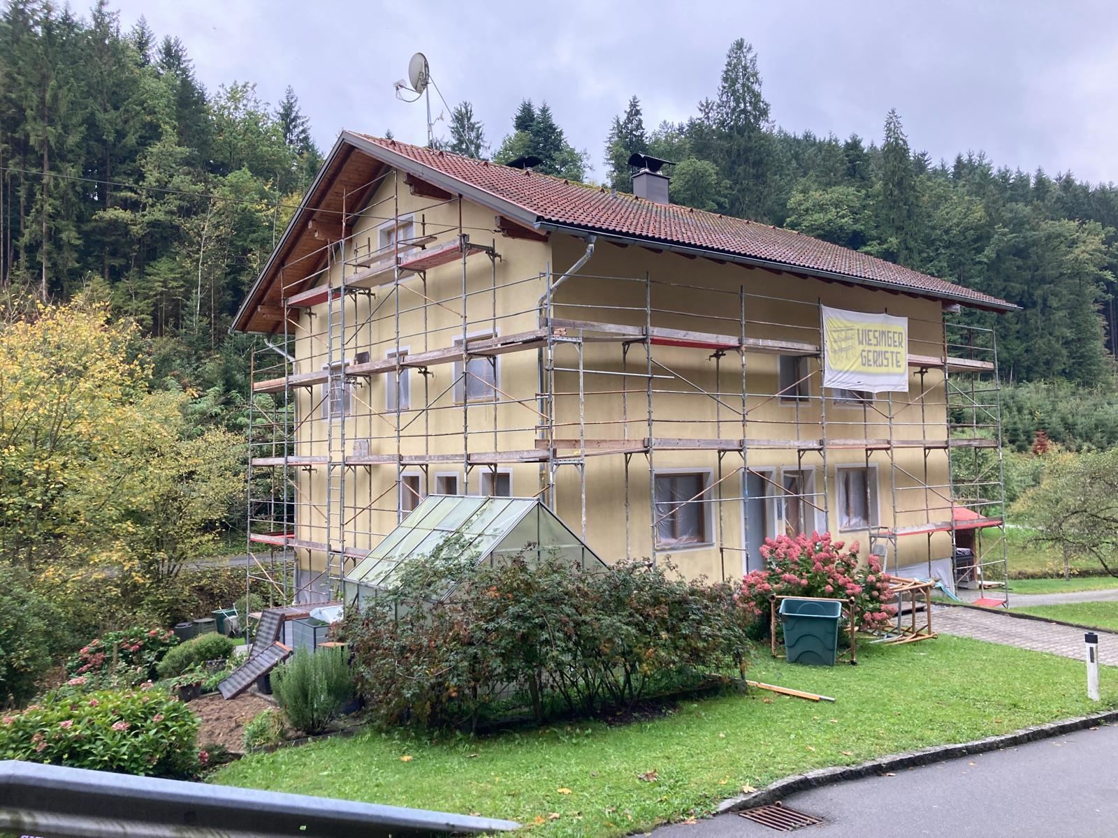 Eingerüstetes Wohnhaus in Waldlage während der Fassadensanierung