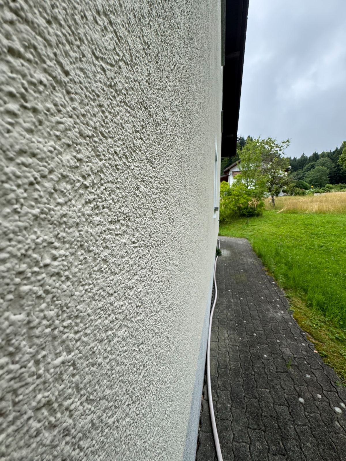 Feine weiße Putzstruktur einer Fassade im Detail