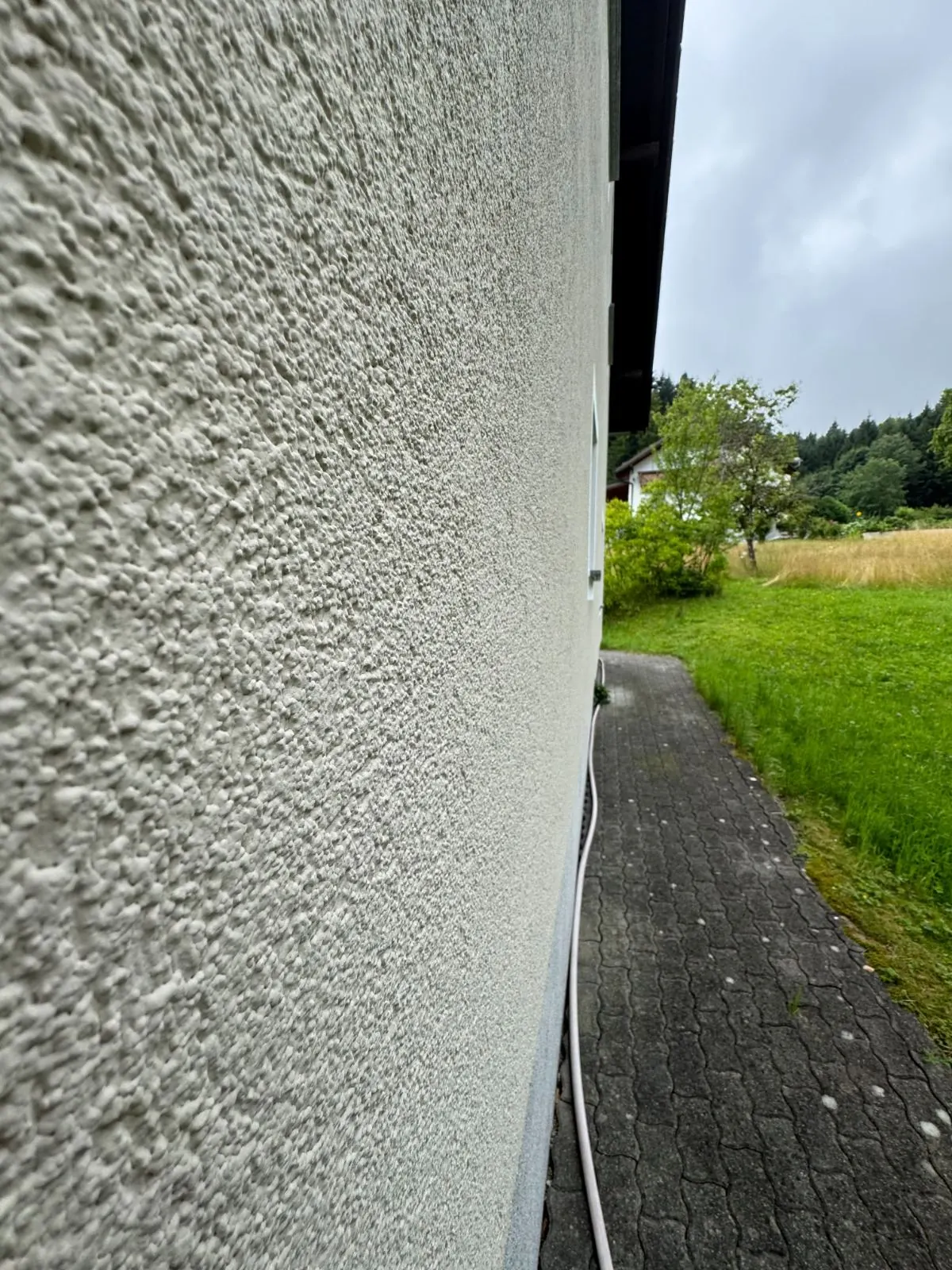Feine weiße Putzstruktur einer Fassade im Detail