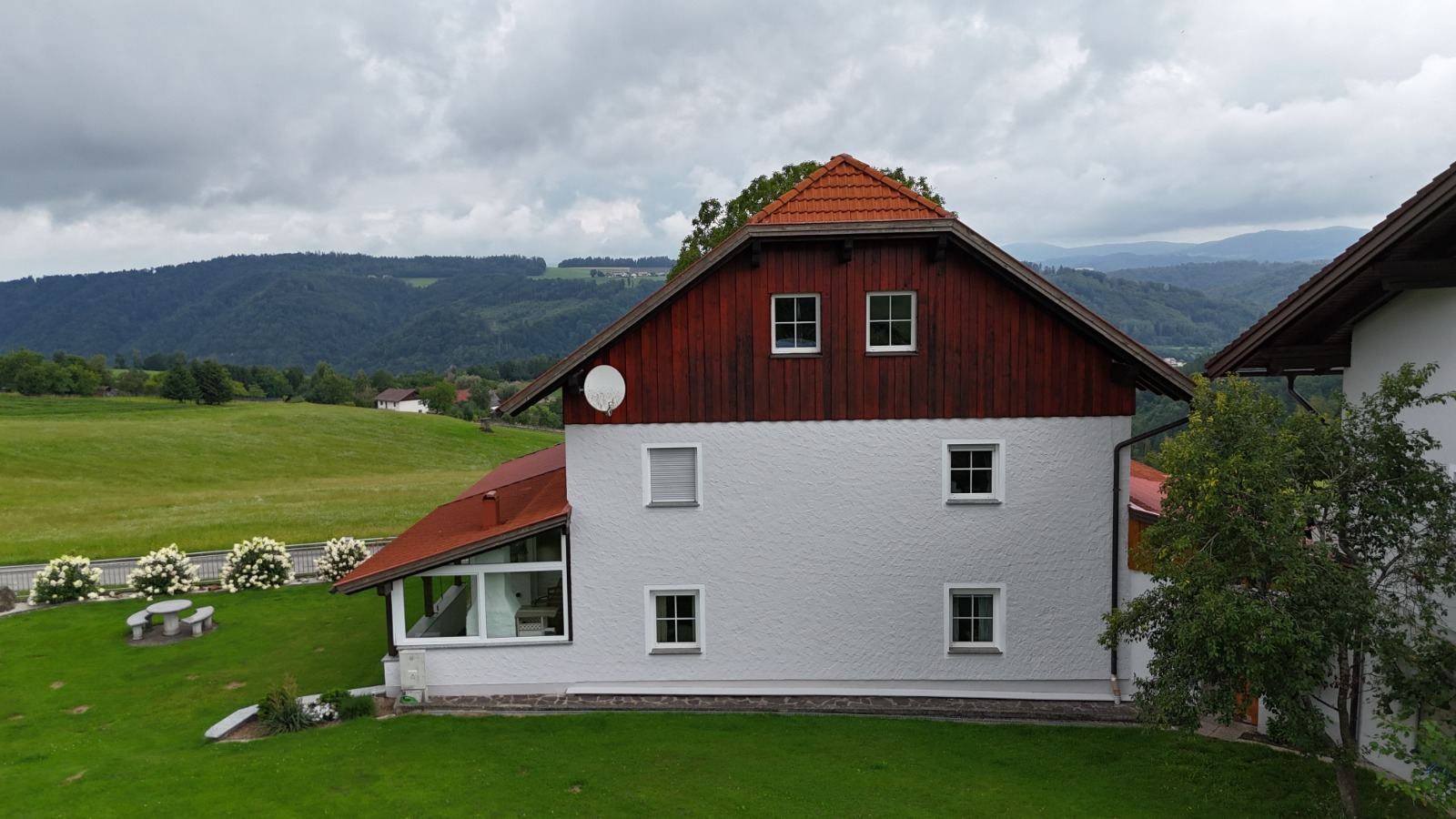 Weißes Wohnhaus mit rotem Dach nach dem Fassadenanstrich