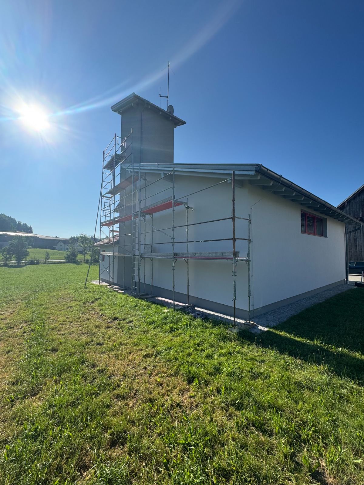 Eingerüstetes Feuerwehrhaus mit Schlauchturm