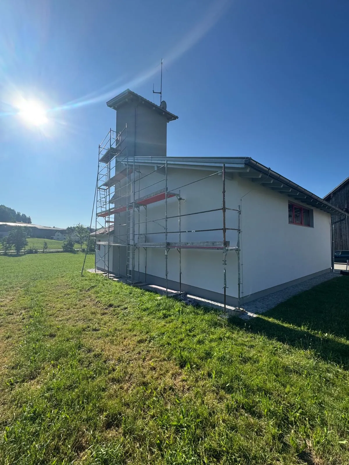 Eingerüstetes Feuerwehrhaus mit Schlauchturm