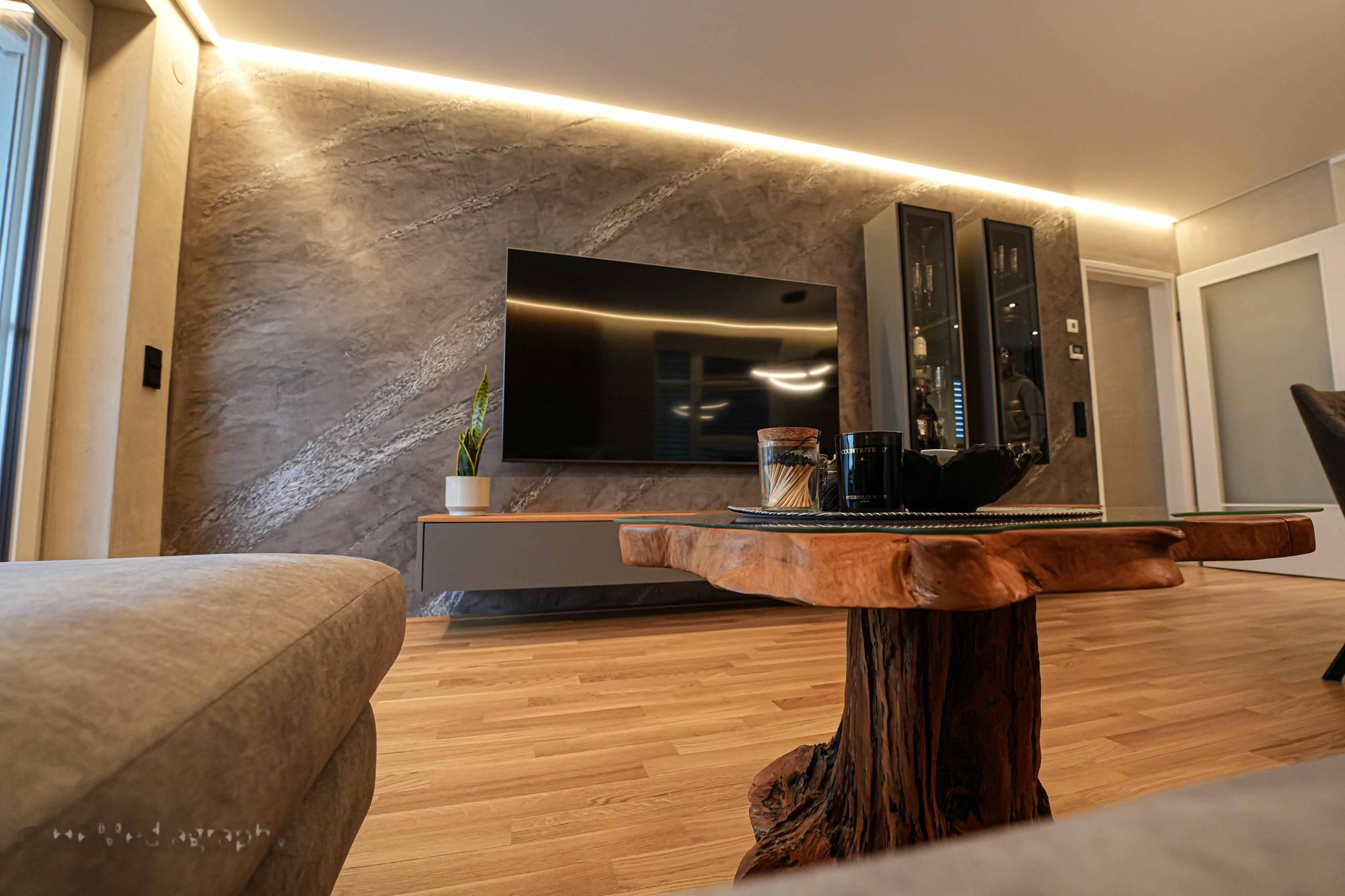 Wohnzimmer mit exklusiver grauer Oberfläche und indirekter Beleuchtung