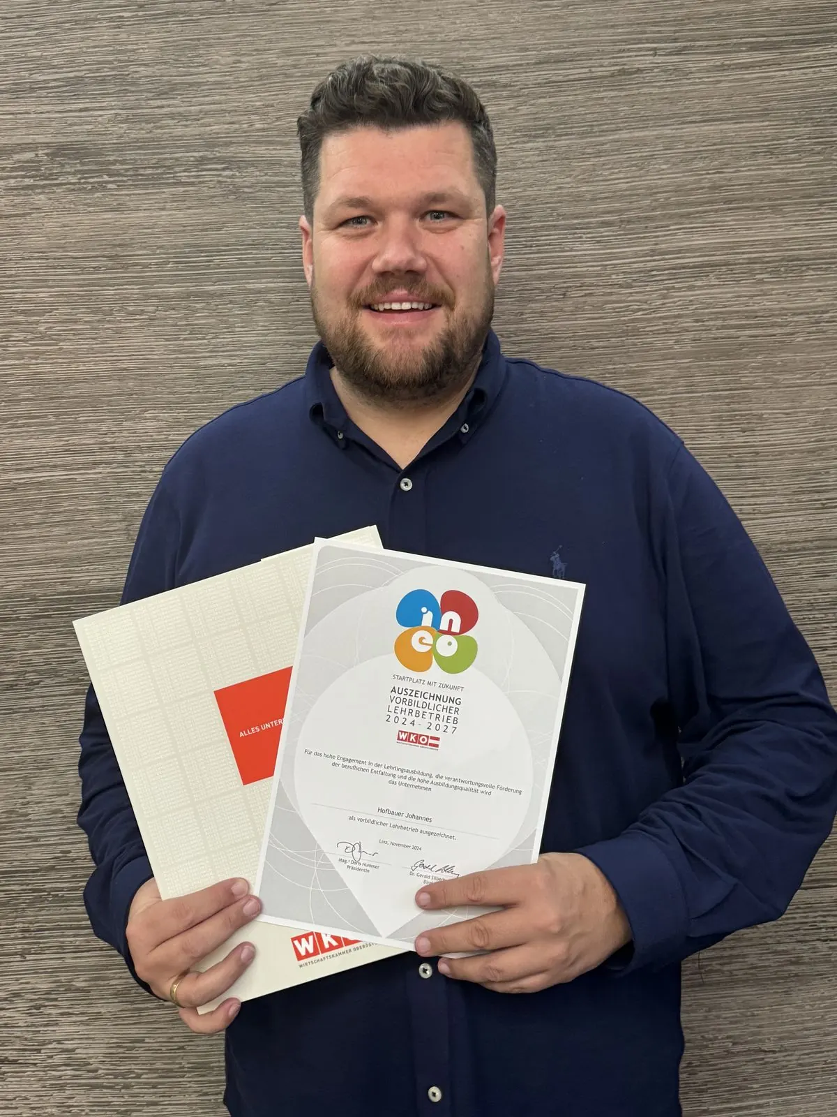 Johannes Hofbauer mit der INEO-Urkunde der WKO Oberösterreich als vorbildlicher Lehrbetrieb