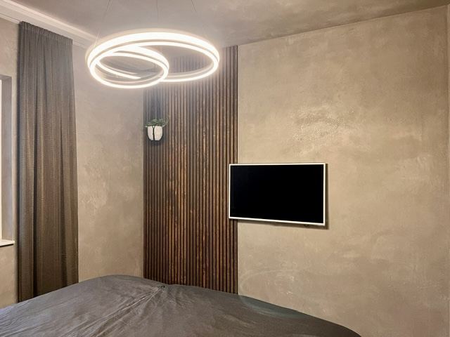 Schlafzimmer mit Kalkputz und Holzpaneelen