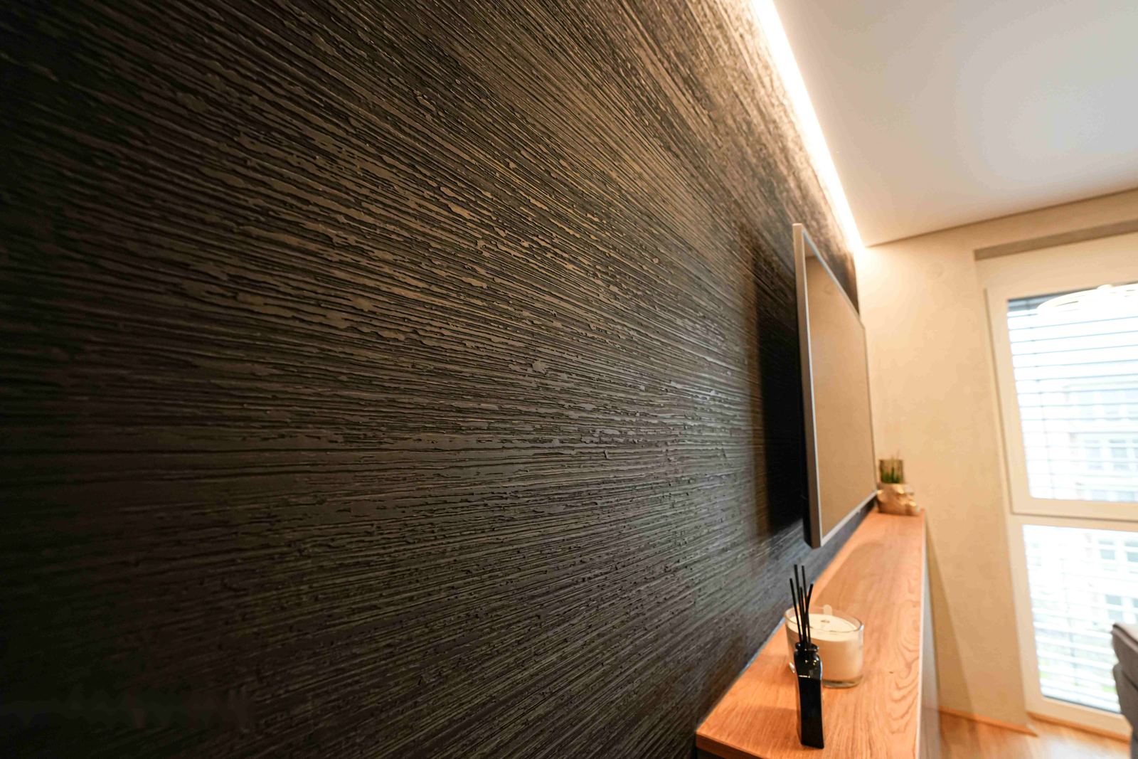 Schwarze strukturierte Wand mit Streiflicht